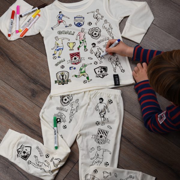 boy colouring in football pyjamas using fabric pens