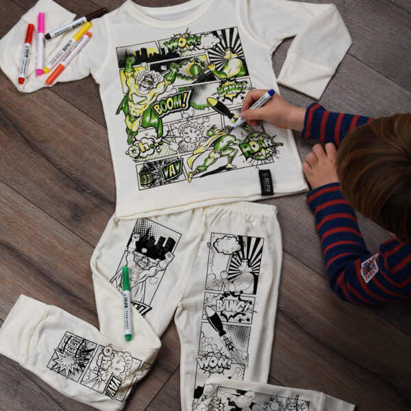 boy colouring in comic book pyjamas using fabric pens